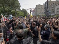 Iranian mourners are beating themselves while participating in a funeral ceremony for Hamas leader Ismail Haniyeh and his bodyguard Abu Shaa...