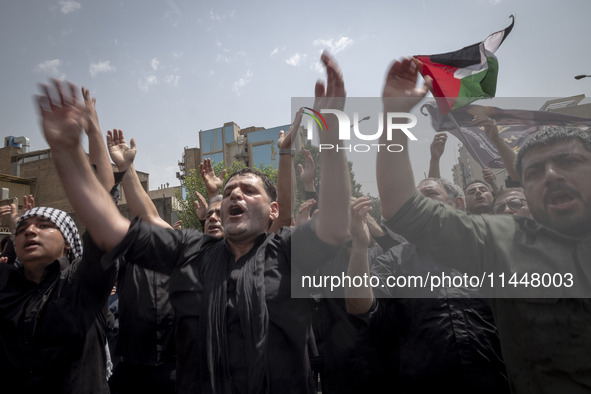 Iranian mourners are beating themselves while participating in a funeral ceremony for Hamas leader Ismail Haniyeh and his bodyguard Abu Shaa...