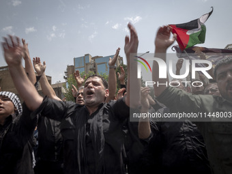 Iranian mourners are beating themselves while participating in a funeral ceremony for Hamas leader Ismail Haniyeh and his bodyguard Abu Shaa...