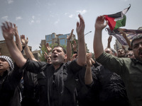 Iranian mourners are beating themselves while participating in a funeral ceremony for Hamas leader Ismail Haniyeh and his bodyguard Abu Shaa...