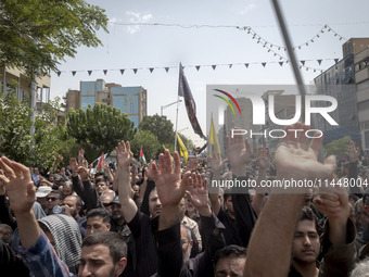 Iranian mourners are beating themselves while participating in a funeral ceremony for Hamas leader Ismail Haniyeh and his bodyguard Abu Shaa...