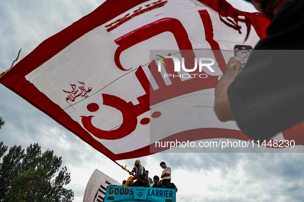 Shia devotees are raising flags during the 25th Muharram procession in Baramulla, Jammu and Kashmir, India, on August 1, 2024. 