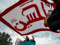 Shia devotees are raising flags during the 25th Muharram procession in Baramulla, Jammu and Kashmir, India, on August 1, 2024. (