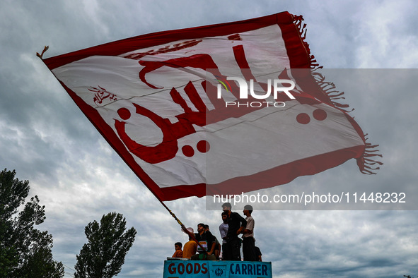 Shia devotees are raising flags during the 25th Muharram procession in Baramulla, Jammu and Kashmir, India, on August 1, 2024. 