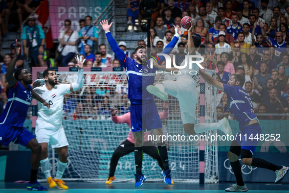 Yahia OMAR of the Egypt team is shooting at the goal against Ludovic FABREGAS of the France team during the men's Handball Preliminary Round...