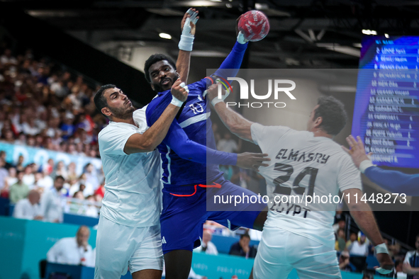 Dika MEM of the France team is shooting at the goal against Abdelrahman ABDOU and Ibrahim ELMASRY of the Egypt team during the men's Handbal...