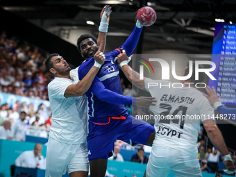 Dika MEM of the France team is shooting at the goal against Abdelrahman ABDOU and Ibrahim ELMASRY of the Egypt team during the men's Handbal...