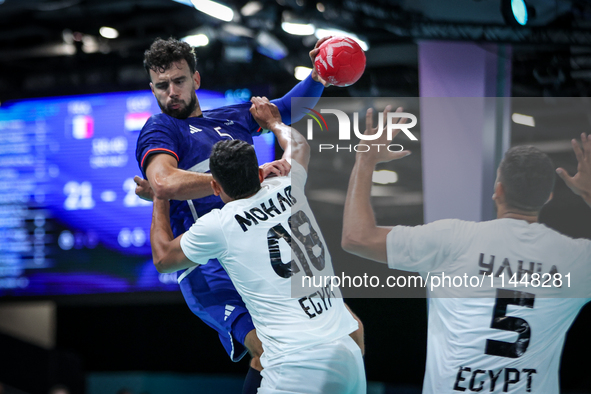 Nedim Remili of the France team is shooting at the goal against Mohab Abdelhak of the Egypt team during the men's Handball Preliminary Round...