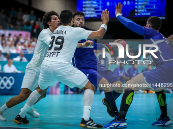 Nedim REMILI of the France team is shooting at the goal against Ali ZEIN and Yehia ELDERAA of the Egypt team during the men's Handball Preli...