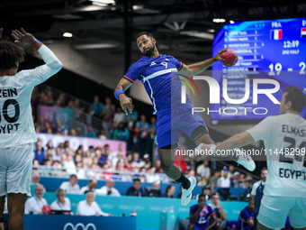 Melvyn Richardson of the France team is shooting at the goal during the men's Handball Preliminary Round - Group B match between France and...