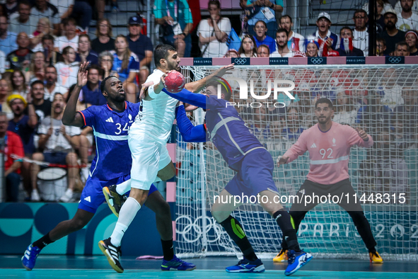 Yehia ELDERAA of the Egypt team is shooting at the goal against Karl KONAN and Ludovic FABREGAS of the France team during the men's Handball...