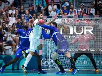 Yehia ELDERAA of the Egypt team is shooting at the goal against Karl KONAN and Ludovic FABREGAS of the France team during the men's Handball...