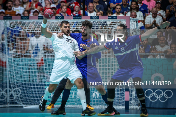 Yehia ELDERAA of the Egypt team is shooting at the goal against Nedim REMILI and Elohim PRANDI of the France team during the men's Handball...