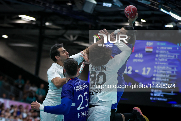 Elohim PRANDI of the France team is shooting at the goal against Ibrahim ELMASRY and Ali ZEIN of the Egypt team during the men's Handball Pr...