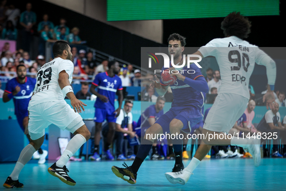 Nedim REMILI of the France team is shooting at goal against Yehia ELDERAA and Ali ZEIN of the Egypt team during the men's Handball Prelimina...