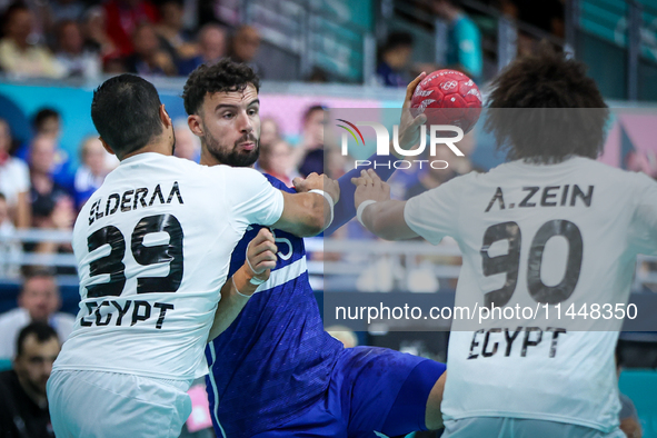 Nedim REMILI of the France team is shooting at the goal against Yehia ELDERAA and Ali ZEIN of the Egypt team during the men's Handball Preli...