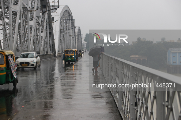 Commuters are crossing Vivekananda Bridge over the River Ganga during monsoon rain in Kolkata, India, on August 1, 2024. 