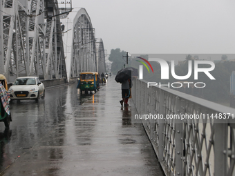 Commuters are crossing Vivekananda Bridge over the River Ganga during monsoon rain in Kolkata, India, on August 1, 2024. (