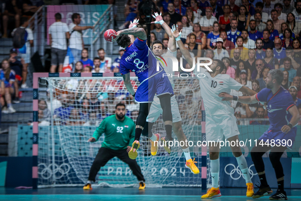 Elohim PRANDI of the France team is shooting at the goal against Ibrahim ELMASRY and Abdelrahman ABDOU of the Egypt team during the men's Ha...