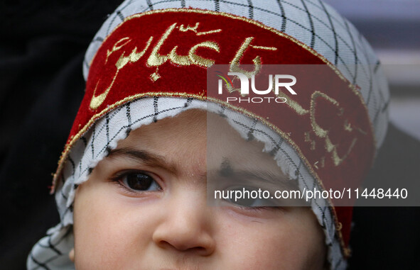 A Shiite Muslim child is looking on during a religious procession in Srinagar, Jammu and Kashmir, on August 01, 2024. 