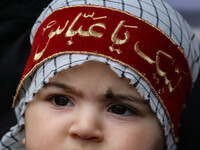 A Shiite Muslim child is looking on during a religious procession in Srinagar, Jammu and Kashmir, on August 01, 2024. (