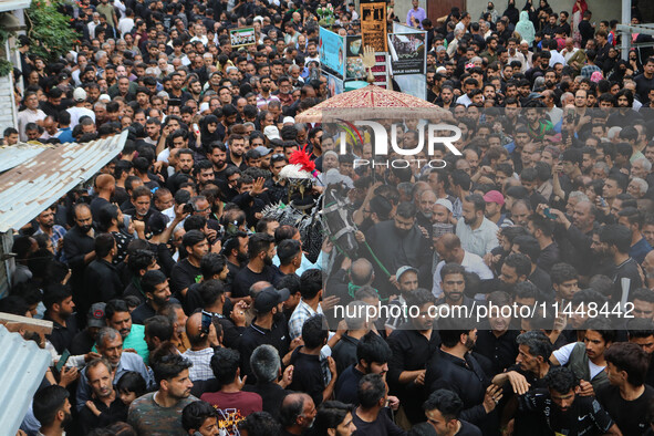 Kashmiri Shiite Muslims are reenacting the scene by touching the horse during a religious procession in Srinagar, Jammu and Kashmir, on Augu...