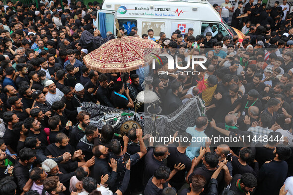 Kashmiri Shiite Muslims are reenacting the scene by touching the horse during a religious procession in Srinagar, Jammu and Kashmir, on Augu...