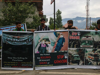 Kashmiri Shiite Muslims are holding banners during a religious procession on the 25th day of the Islamic month of Muharram in Srinagar, Jamm...