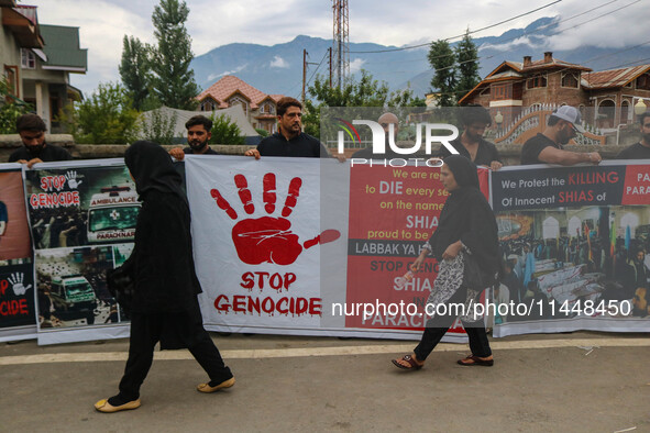 A woman is walking past Kashmiri Shiite Muslims holding banners during a religious procession on the 25th day of the Islamic month of Muharr...