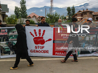 A woman is walking past Kashmiri Shiite Muslims holding banners during a religious procession on the 25th day of the Islamic month of Muharr...