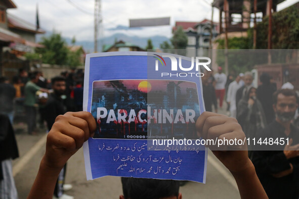 A boy is holding a placard during a religious procession on the 25th day of the Islamic month of Muharram in Srinagar, Jammu and Kashmir, on...