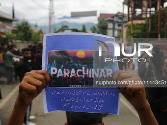 A boy is holding a placard during a religious procession on the 25th day of the Islamic month of Muharram in Srinagar, Jammu and Kashmir, on...