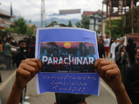 A boy is holding a placard during a religious procession on the 25th day of the Islamic month of Muharram in Srinagar, Jammu and Kashmir, on...