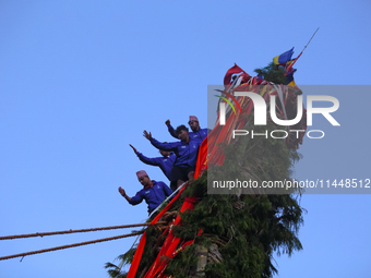 Nepali devotees are climbing up the chariot of the Red God, Rato Macchindranath, as it approaches the final tour of the city, wrapping up th...