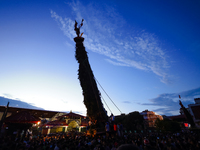 The sky-scraping chariot of the Red God, Rato Macchindranath, is silhouetted against the backdrop of the setting sun after it is installed a...