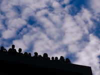 Nepali Hindu devotees are silhouetted against the sky filled with monsoon clouds as they are observing the procession of Red God- Rato Macch...