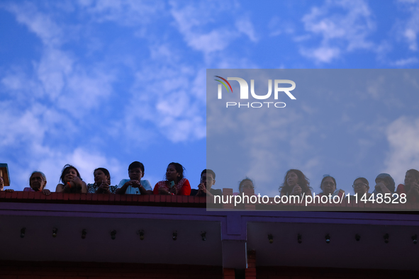 Nepali Hindu devotees are silhouetted against the sky filled with monsoon clouds as they are observing the procession of Red God- Rato Macch...