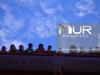 Nepali Hindu devotees are silhouetted against the sky filled with monsoon clouds as they are observing the procession of Red God- Rato Macch...