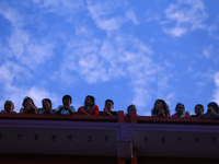 Nepali Hindu devotees are silhouetted against the sky filled with monsoon clouds as they are observing the procession of Red God- Rato Macch...