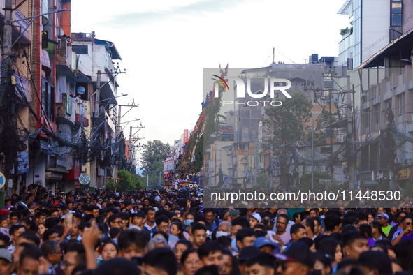 The sky-scraping chariot of the Red God, Rato Macchindranath, is wading through a sea of devotees as it approaches the final tour of the cit...