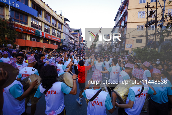 Nepali devotees are playing traditional musical instruments as the procession of the Red God, Rato Macchindranath, is approaching the final...