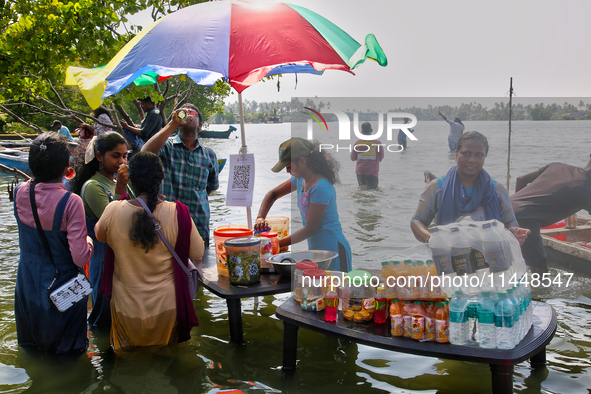 Women are preparing snacks at a small snack stand in the water along Sambranikodi Island in Kerala, India, on April 06, 2024. Sambranikodi I...