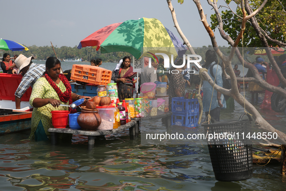 A woman is preparing snacks at a small snack stand in the water along Sambranikodi Island in Kerala, India, on April 06, 2024. Sambranikodi...