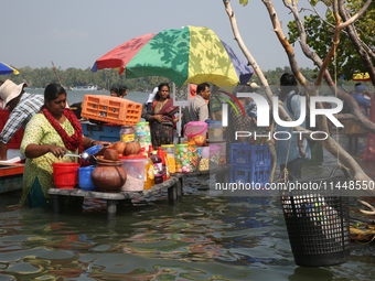 A woman is preparing snacks at a small snack stand in the water along Sambranikodi Island in Kerala, India, on April 06, 2024. Sambranikodi...