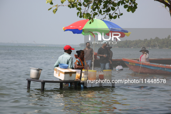 A woman is preparing snacks at a small snack stand in the water along Sambranikodi Island in Kerala, India, on April 06, 2024. Sambranikodi...