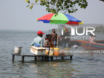 A woman is preparing snacks at a small snack stand in the water along Sambranikodi Island in Kerala, India, on April 06, 2024. Sambranikodi...