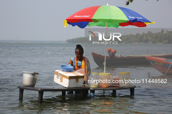 A woman is preparing snacks at a small snack stand in the water along Sambranikodi Island in Kerala, India, on April 06, 2024. Sambranikodi...