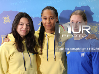 Ukrainian epee fencers Vlada Kharkova, Dzhoan Feybi Bezhura, and Olena Kryvytska (L to R) are posing for a photo upon coming back from the P...