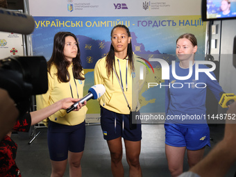 Ukrainian epee fencers Vlada Kharkova, Dzhoan Feybi Bezhura, and Olena Kryvytska (L to R) are answering reporters' questions upon coming bac...