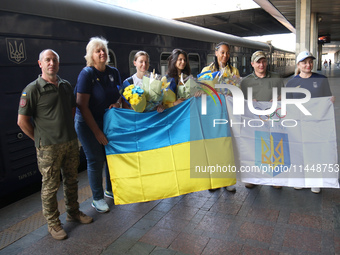 Ukrainian epee fencers Olena Kryvytska (3rd L), Vlada Kharkova (C), and Dzhoan Feybi Bezhura (3rd R) are posing for a photo on the platform...